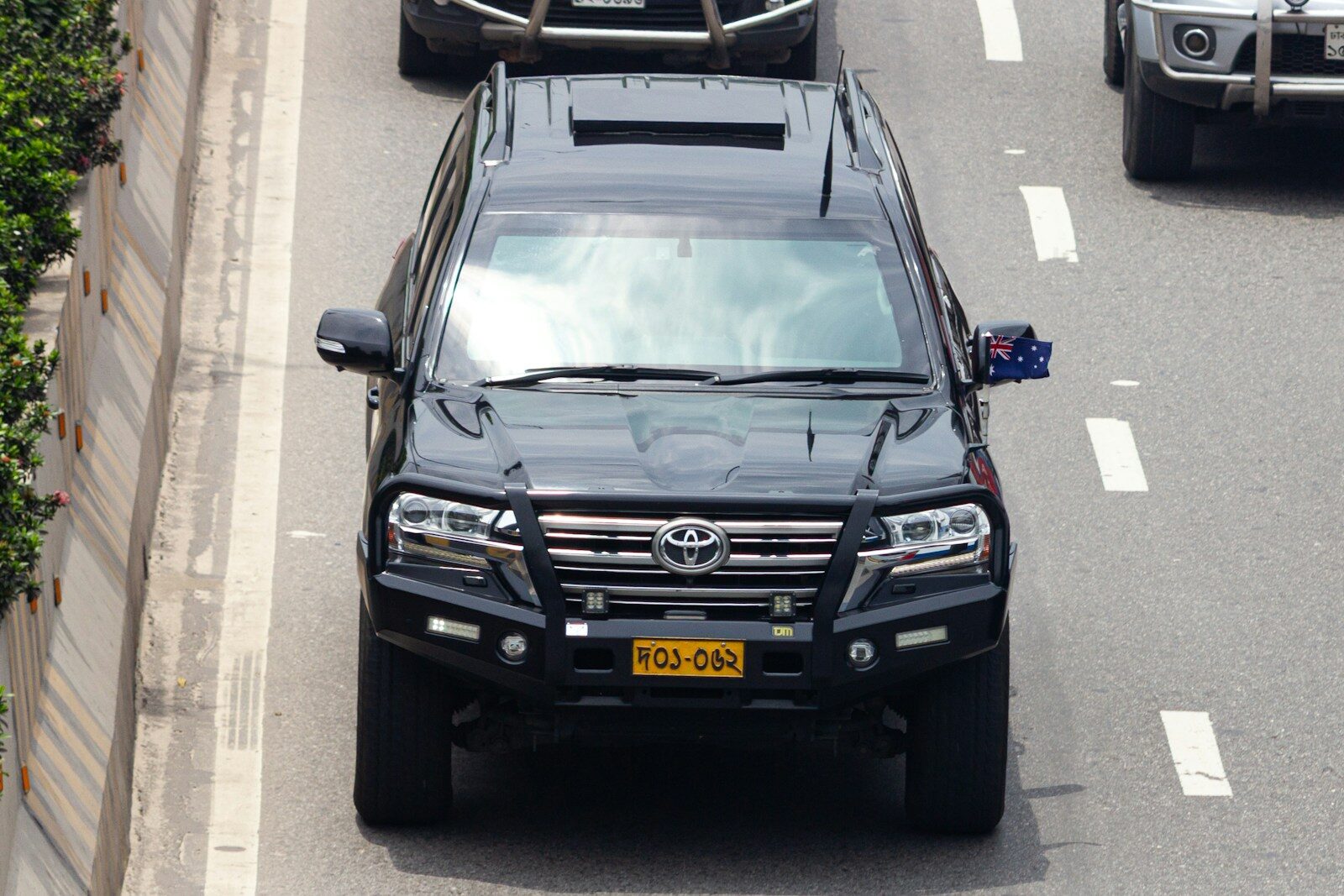 Black suv driving on a highway with other cars.
